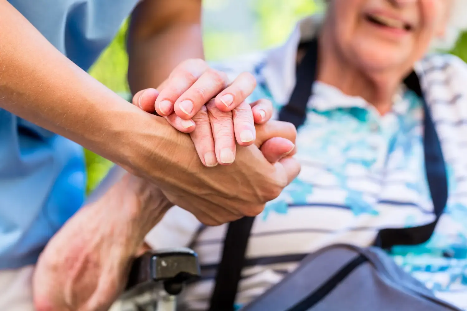 Vital Plus Pflegedienst - Krankenschwester tröstet ältere Frau, hält ihre Hand